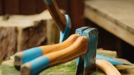 Four axes with wooden handles on a tree stump