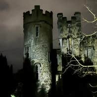 A large round castle turret lit up at night