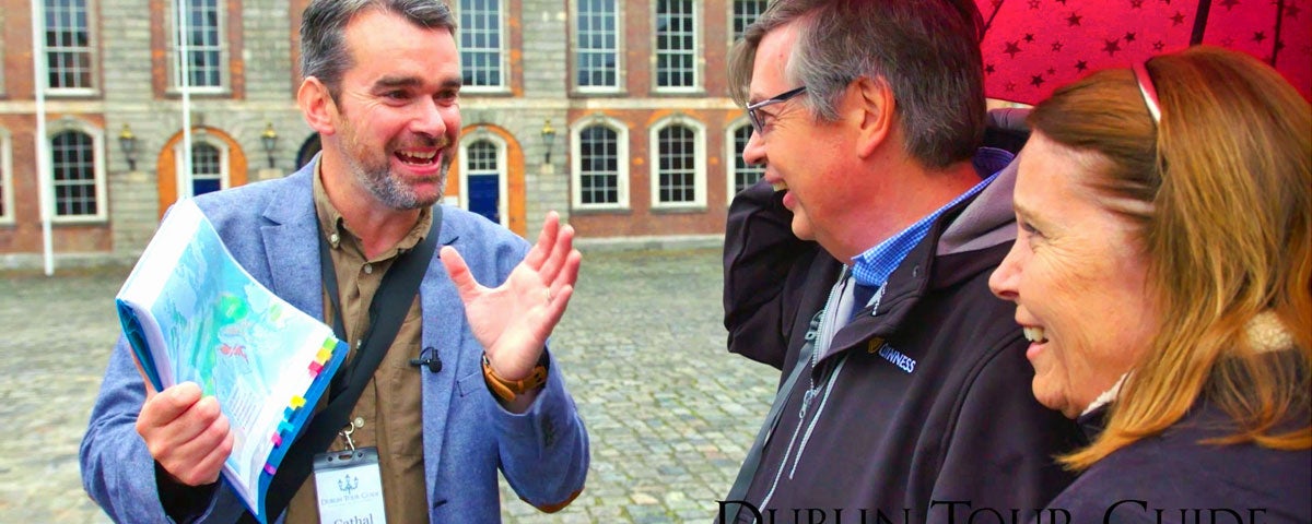 One of the guides with name badge Cathal Sheehan talking to a couple on the tour with a map visible in his hand