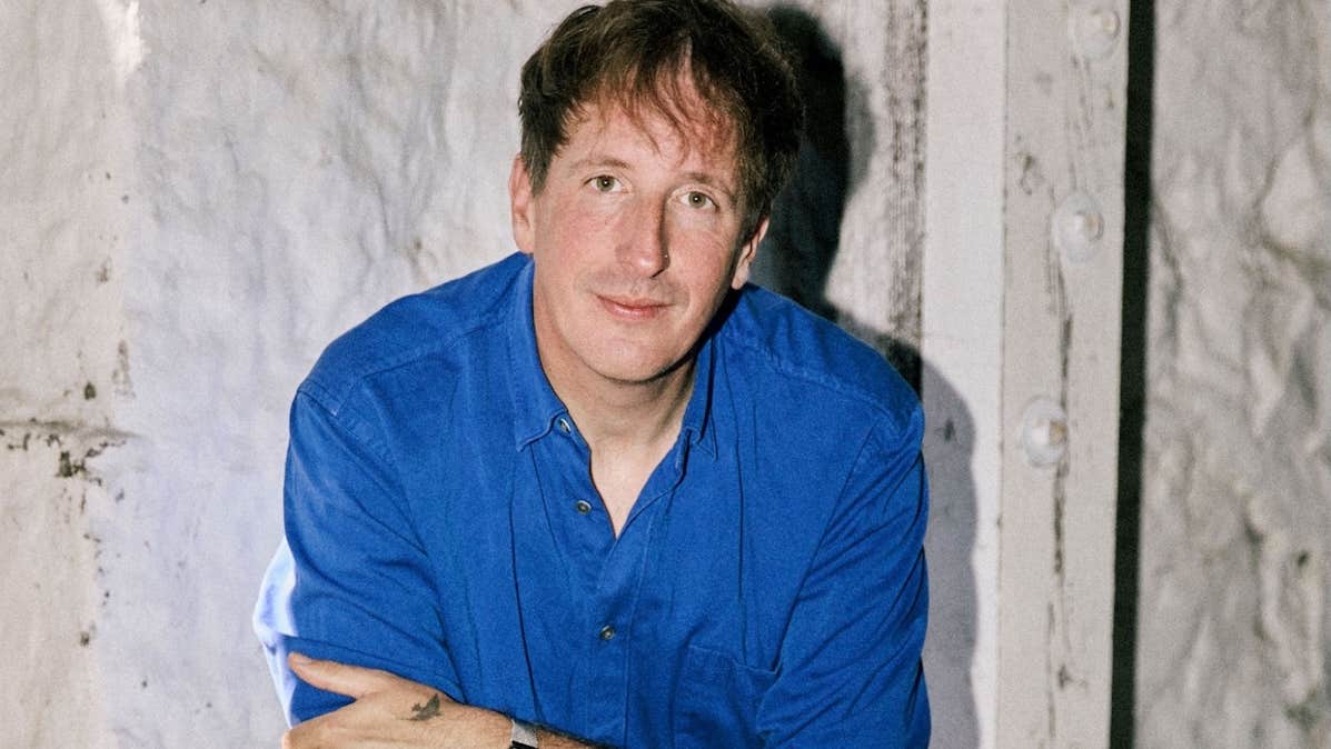 German producer and artist, Christian Löffler, man in dark blue shirt with arms crossed.