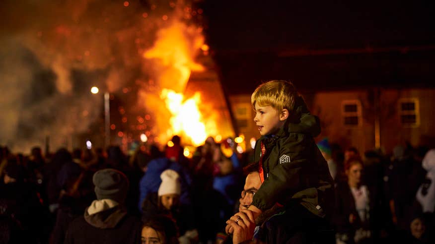 Boy sitting on his father's shoulders to watch the Samhain Procession in Longford.