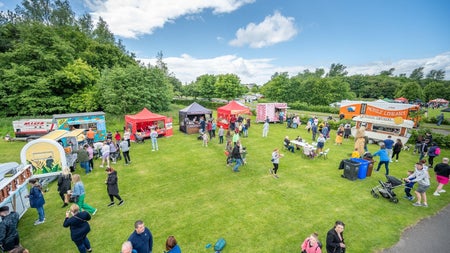 Aerial image of people in a park with market stalls all around