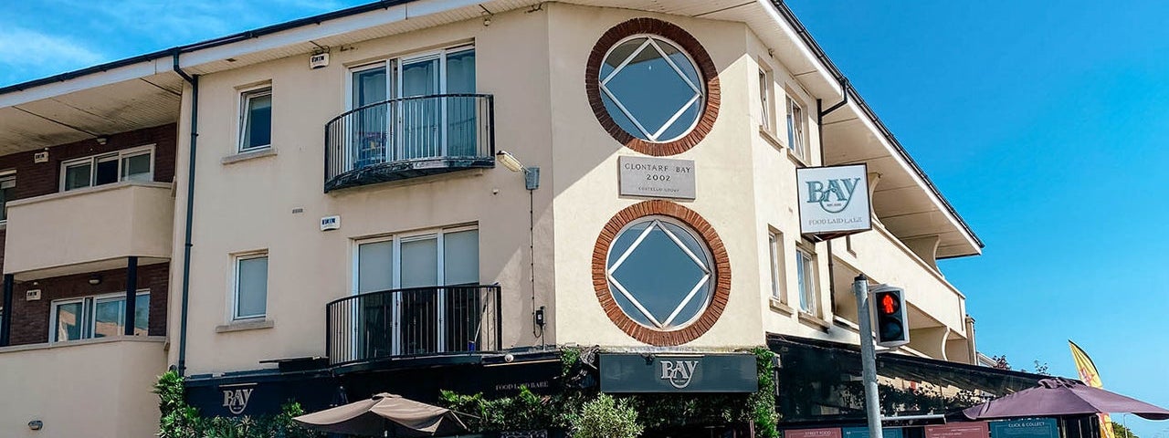 Exterior view of the Bay Restaurant with people dining al fresco