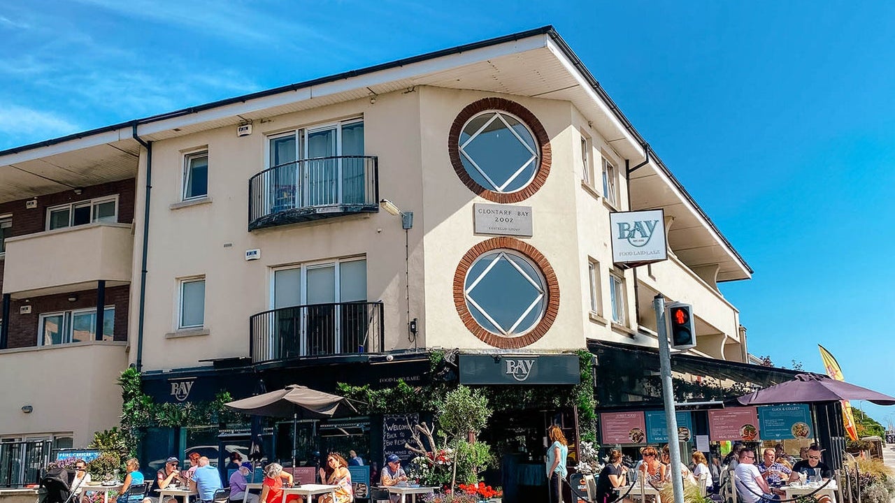 Exterior view of the Bay Restaurant with people dining al fresco