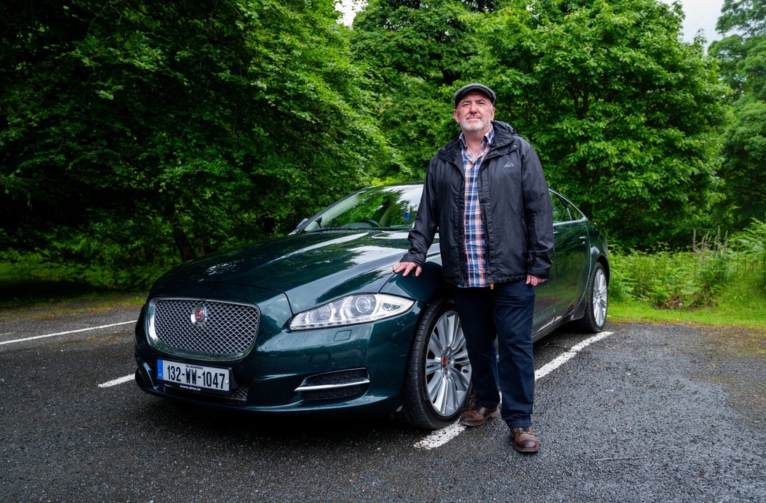 A man posing with a car