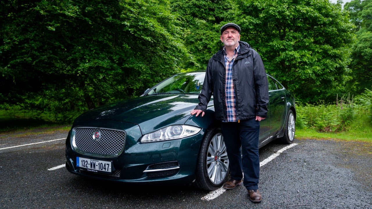 A man posing with a car