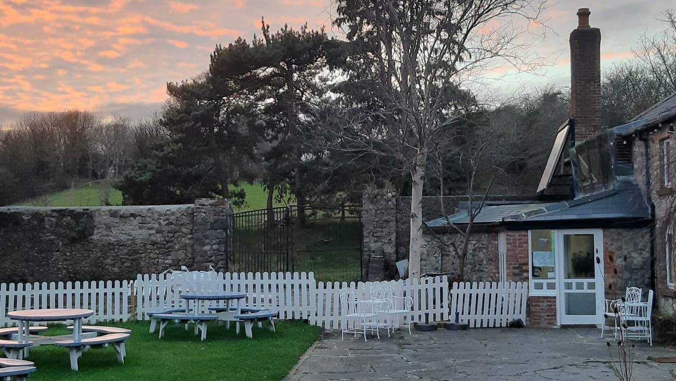 The grounds of a stone building with outside seating