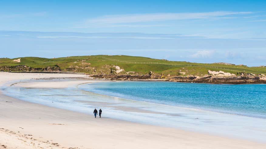 People walking on Dog's Bay Beach in Co Galway