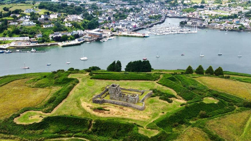 Aerial view of James Fort, Kinsale a historic fortress surrounded by fields and situated next to a river bank.