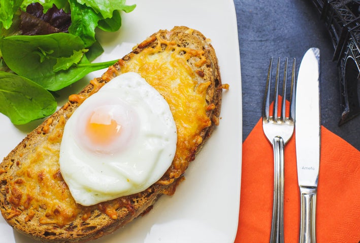 A poached egg sitting on a slice of artisan bread on a plate