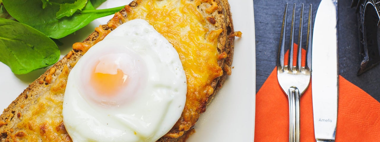 A poached egg sitting on a slice of artisan bread on a plate