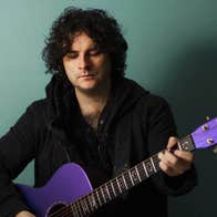 NCH Landmarks: Paddy Casey, a man looking down at purple coloured guitar he is holding