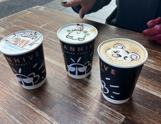 Three cups of coffee with designs on top of the froth