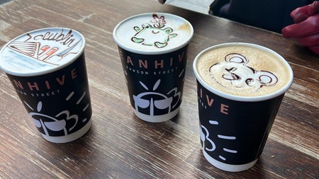 Three cups of coffee with designs on top of the froth