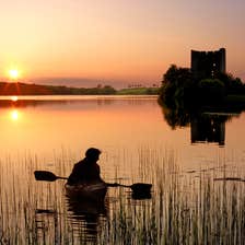 People kayaking past Cloughoughter Castle in Co Cavan