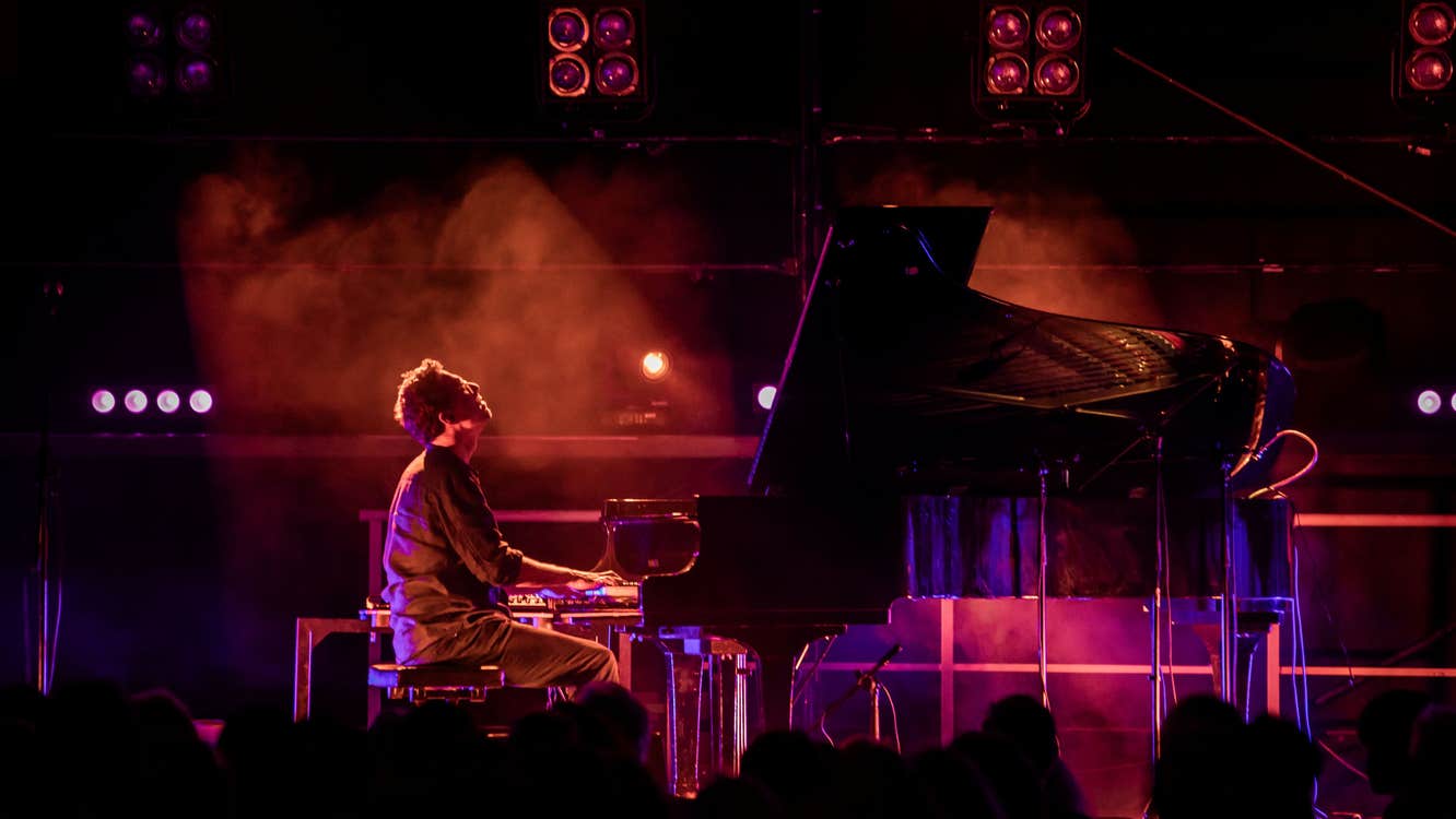 Bill Lauraunce playing a piano on a stage.
