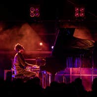Bill Lauraunce playing a piano on a stage.