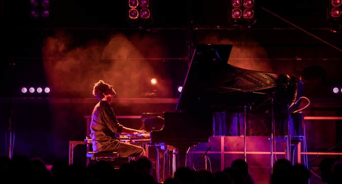 Bill Lauraunce playing a piano on a stage.