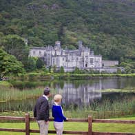 A couple looking at Kylemore Abbey in Connemara in County Galway.