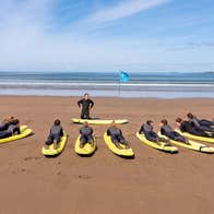 Strandhill Surf School view of ten surfers on boards on the beach with the instructor