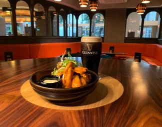 A pint of Guinness on a high table with a food dish