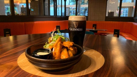 A pint of Guinness on a high table with a food dish