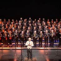 The Bray Community Choir on a large stage with conductor
