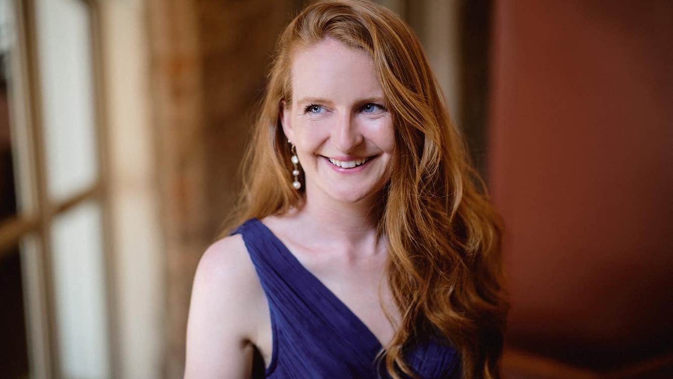 Aisling Kenny, soprano - a smiling woman with long hair in evening dress