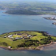 Island from the air with the sea around it and mainland in the background