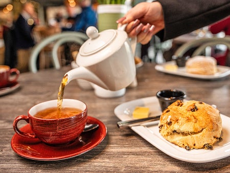 Kilkenny Café view of tea being poured into a tea cup with a fruit scone