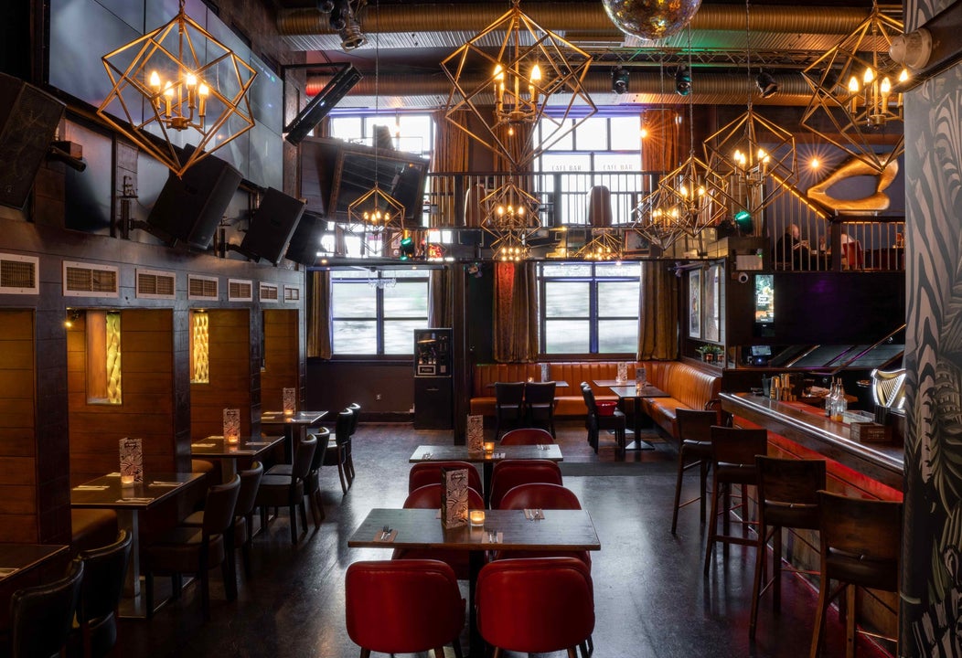 Interior of a pub with booths and chairs at the counter and tables and chairs in the middle