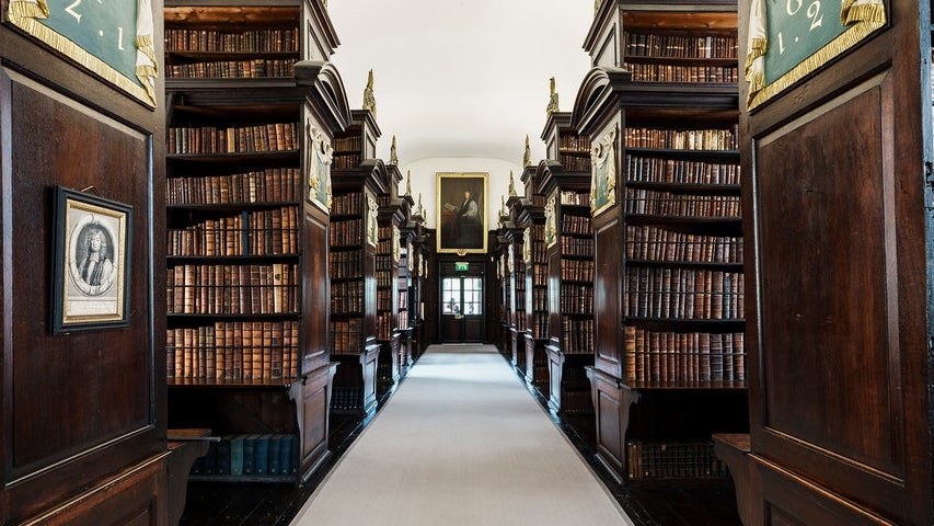 A room with rows of books each side of a walkway