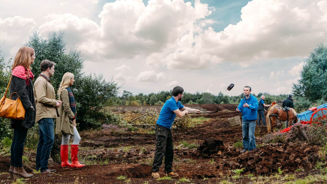 A group of people watching staff demonstrate activities at Lullymore Heritage Park, Co. Kildare