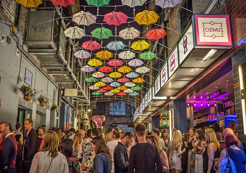 Zozimus Bar exterior street view showing colourful umbrellas overhead at night