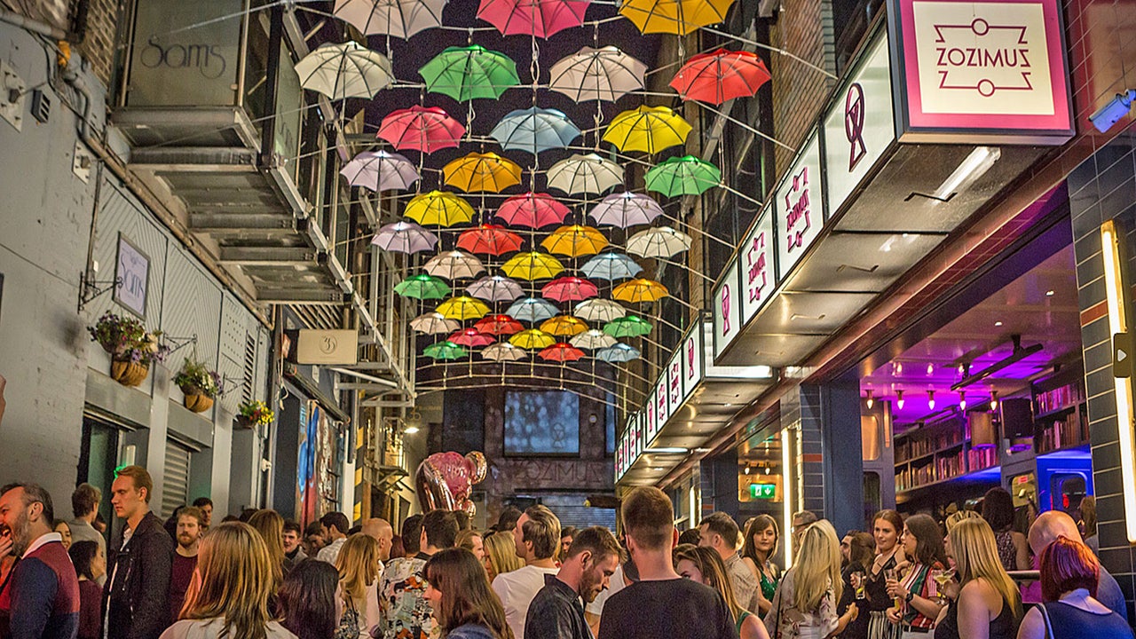 Zozimus Bar exterior street view showing colourful umbrellas overhead at night