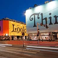 A series of buildings with coverings mentioning the words 'Stop', 'Look' and 'Think'.