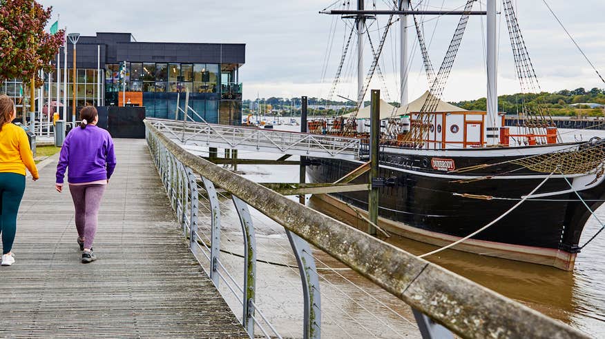 Three people walking to the Dunbrody Famine Ship Experience in County Wexford.