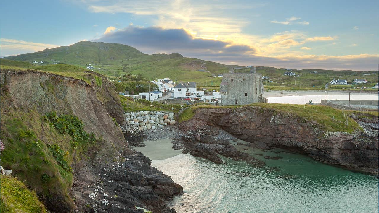 Cliffs and sea with a castle and beach behind