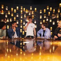 A small group of people at a table with whiskey glasses in front of them