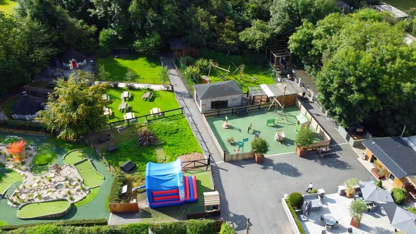 Aerial view of a farm with sheds grass wooden gates and a play area