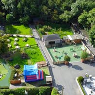 Aerial view of a farm with sheds grass wooden gates and a play area