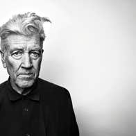 An elderly David Lynch against a blank wall.