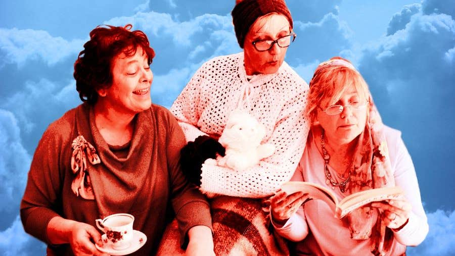 3 older women looking at an open book one of them is holding.