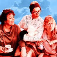 3 older women looking at an open book one of them is holding.