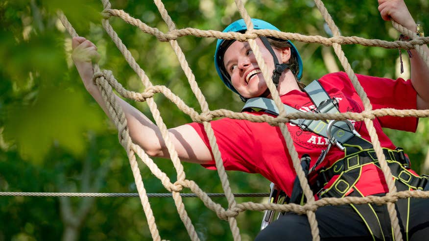 Young person climbing rope ladder in Castlecomer Discovery Park.