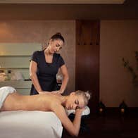 Person lying on a treatment bed being massaged