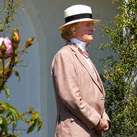 Happy Birthday John McCormack - a man in jacket and straw hat is looking away into the distance with bushes either side of him