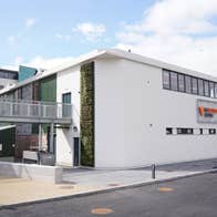 Roadside view of a white building with a metal bridge to the left