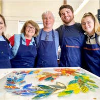 Glasshammer Studios view of five people next to their colourful painted glass project