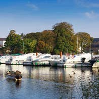 Boats in a marina with a backdrop of trees and a church in Carrick-on-Shannon, County Leitrim